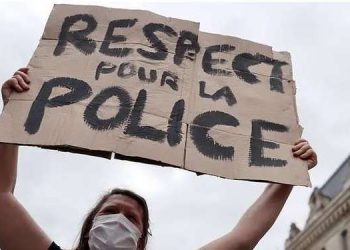 إحدى مؤيدات قوات الشرطة تحمل لافتة كتب عليها إحدى مؤيدات قوات الشرطة تحمل لافتة كتب عليها "احترموا الشرطة" في باريس، فرنسا، 27 يونيو 2020. (رويترز)