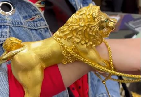 فتاة تشترى ذهبها عبارة عن أسد ضخم على يدها