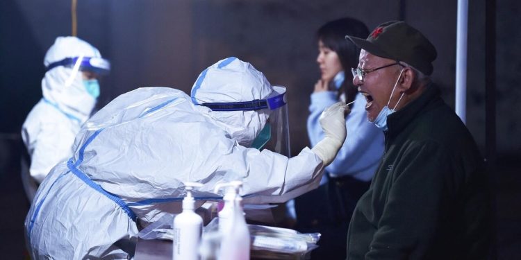 This photo taken on March 16, 2022 shows a resident undergoing a nucleic acid test for the Covid-19 coronavirus in Nanjing in China's eastern Jiangsu province. - Just three weeks ago China was reporting under 100 Covid cases daily, but that number has swelled past 1,000 per day for a week. (Photo by AFP) / China OUT